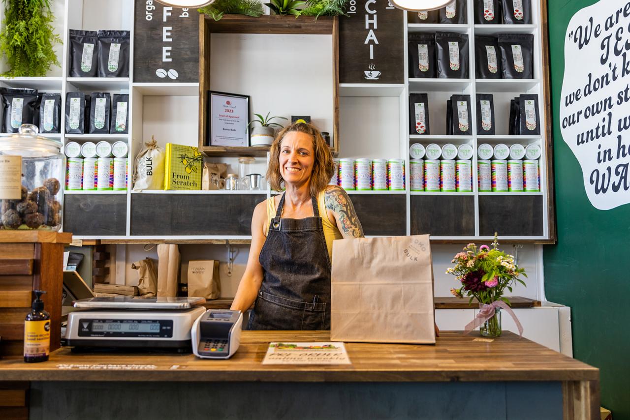 Lady standing at cafe counter smiling