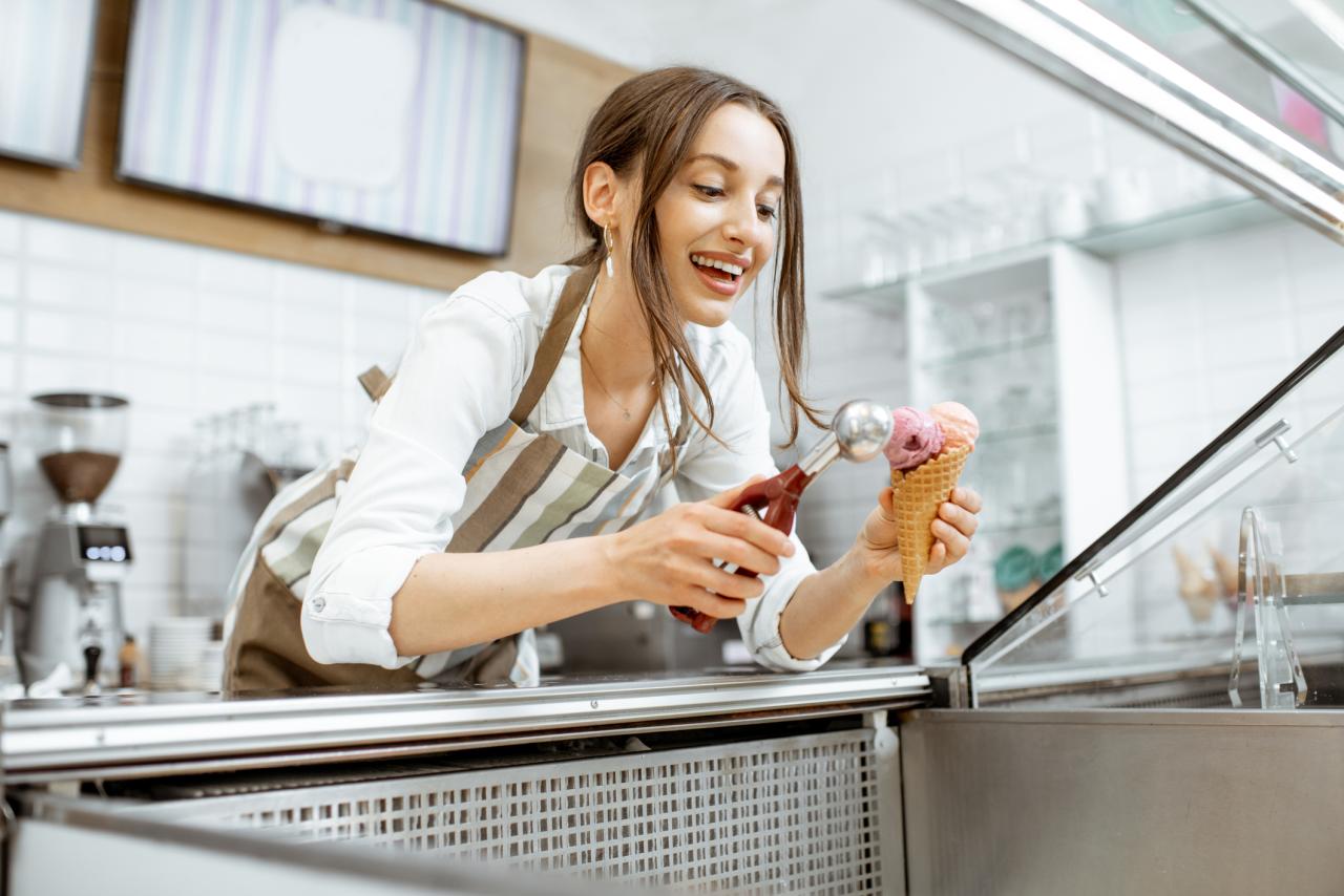 Woman in apron scooping ice cream