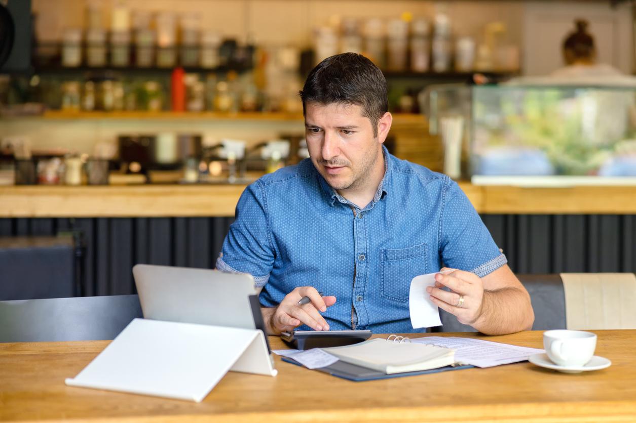 Cafe owner doing bookwork on his computer