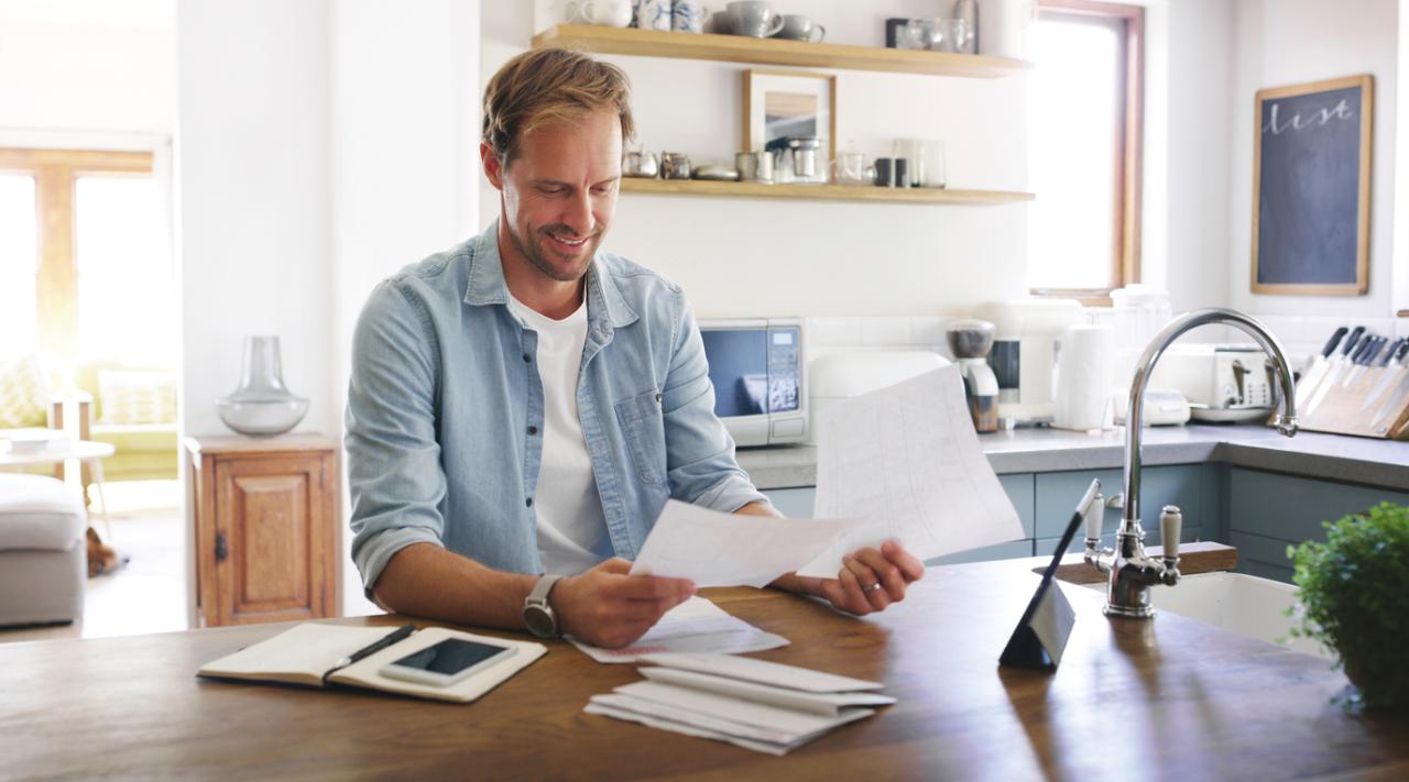 Cropped shot of a man looking cheerful while going through his budget at home