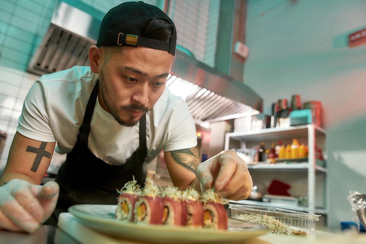 experienced sushi chef carefully adding final touch with dedication to his delicious sushi set