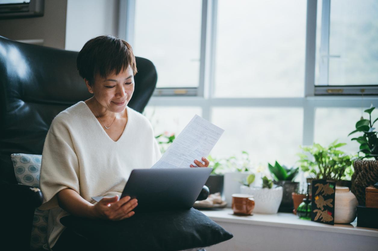 senior Asian woman in checking bills