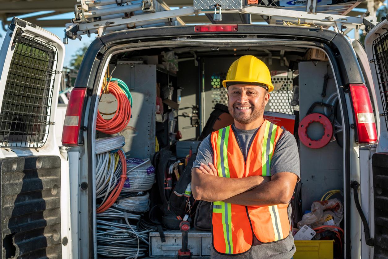 Construction worker standing outside his van