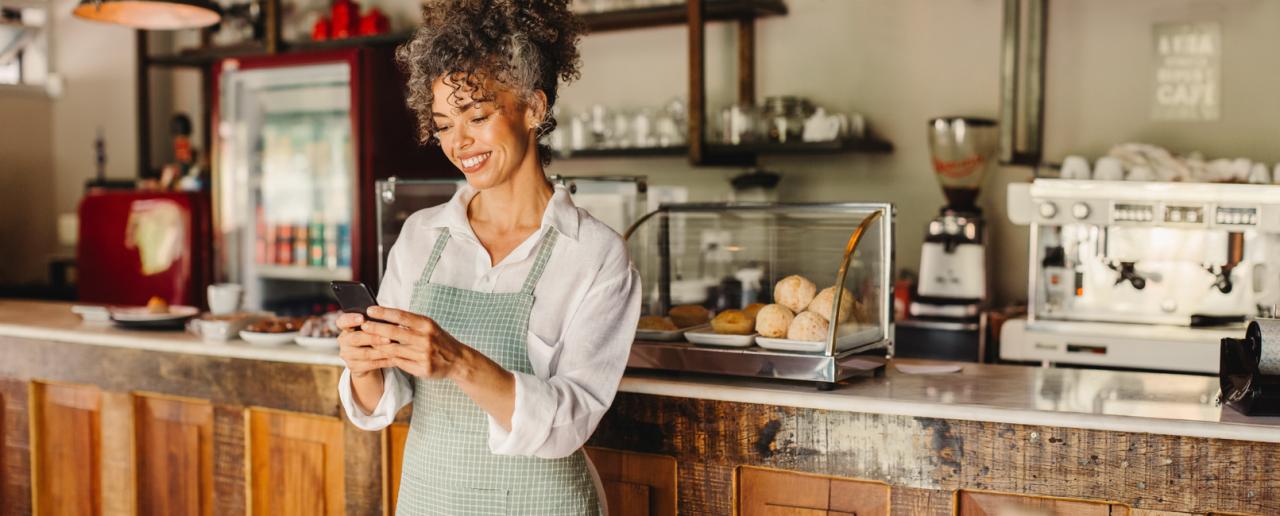 Person leaning on cafe counter on phone