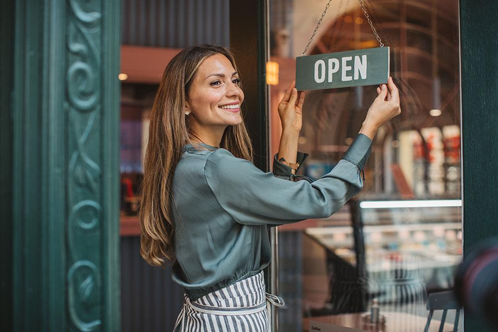 Woman turns shop sign to open