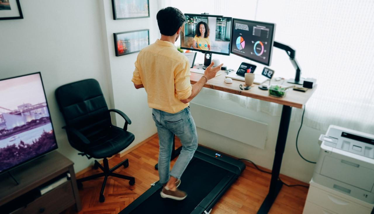 Man on walking pad at desk