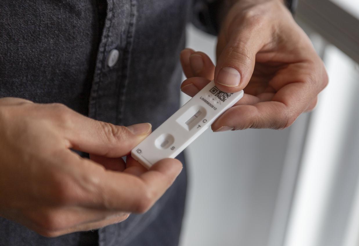 Man holding a rapid antigen test