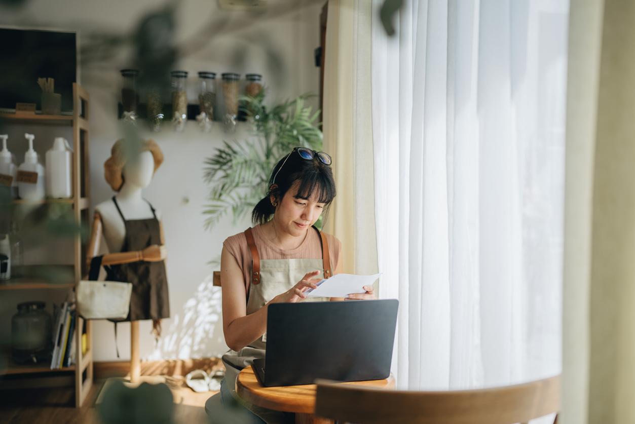 Young female small business owner making expenses at her store