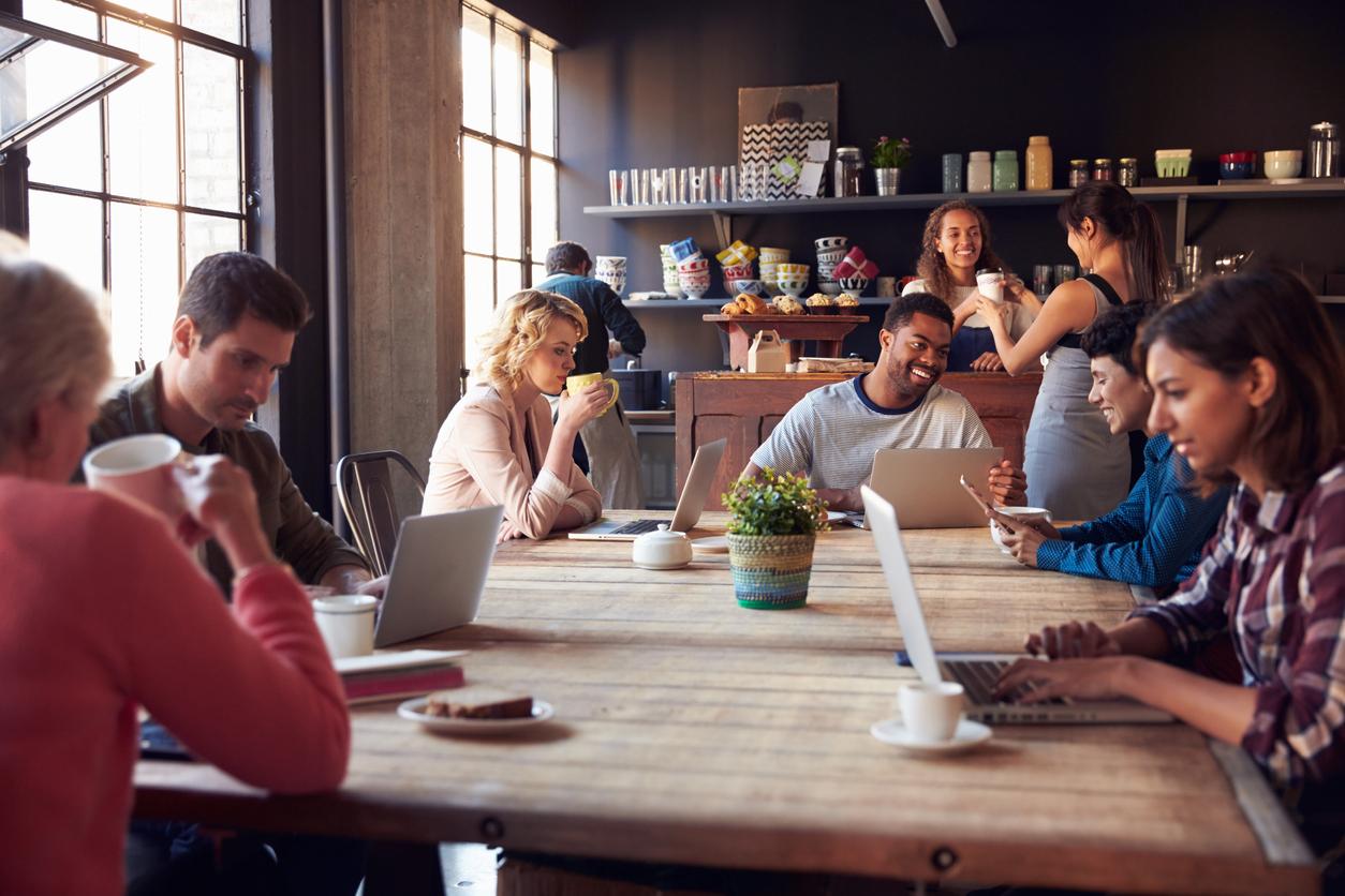 People sitting at shared table in busy cafe