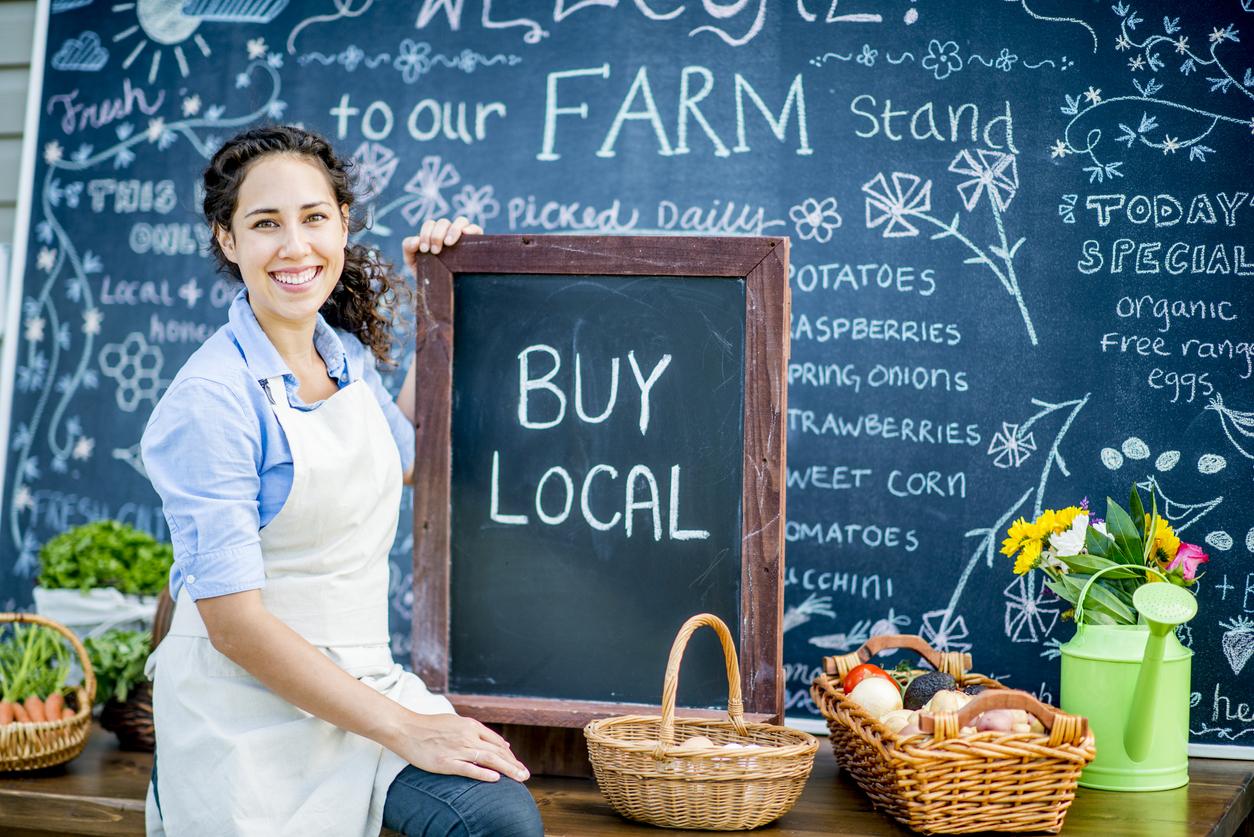 Woman holds buy local sign