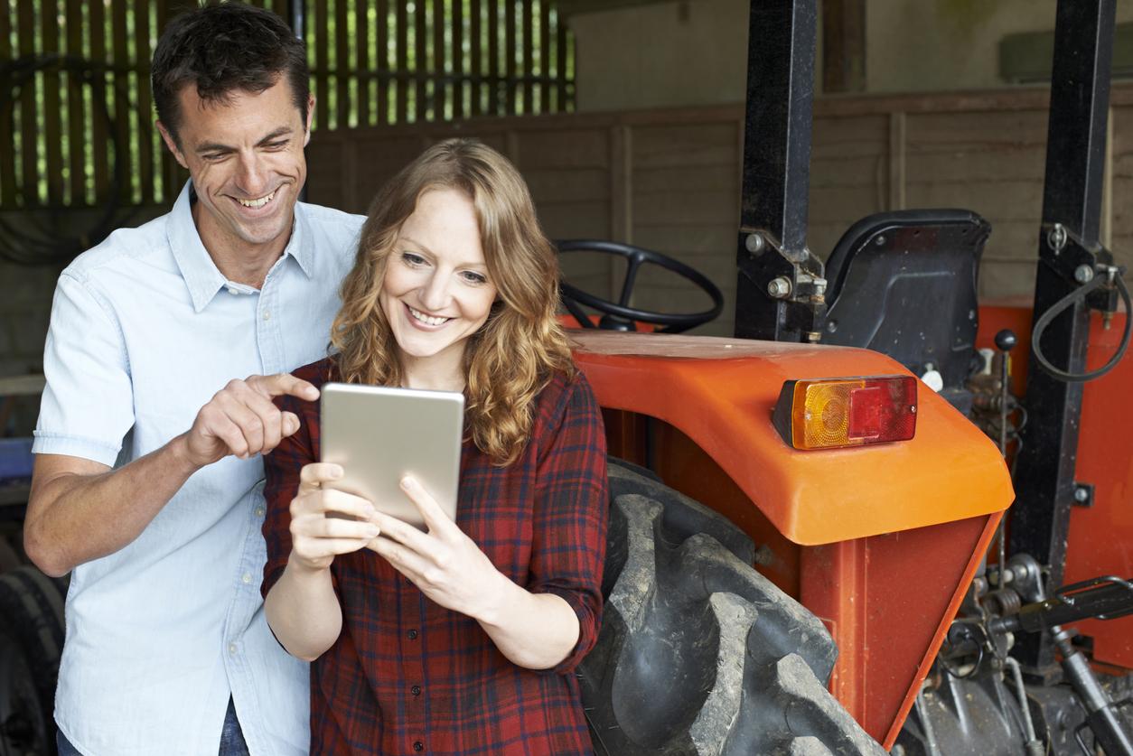 Male And Female Agricultural Workers Looking At Digital Tablet