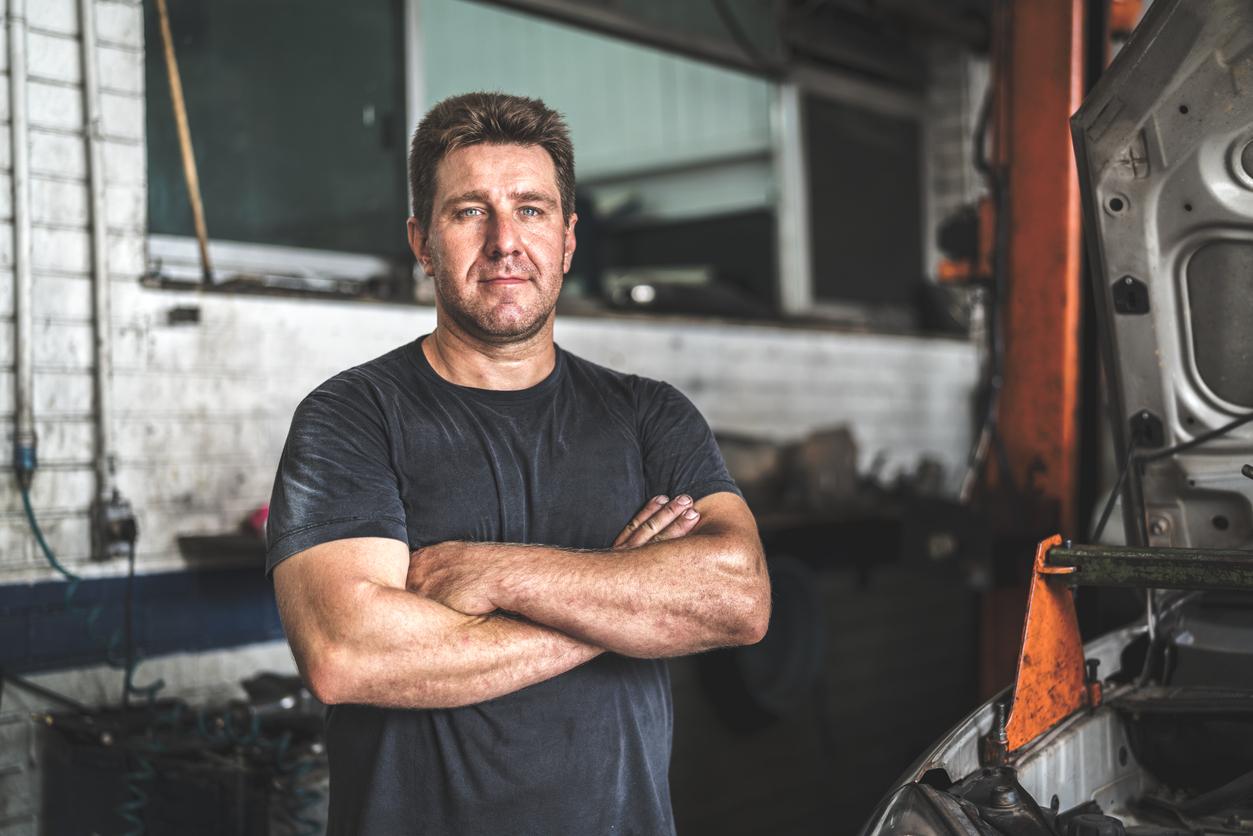 car mechanic standing in his garage