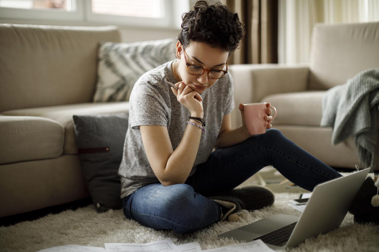 Woman sitting on the ground looking at documents