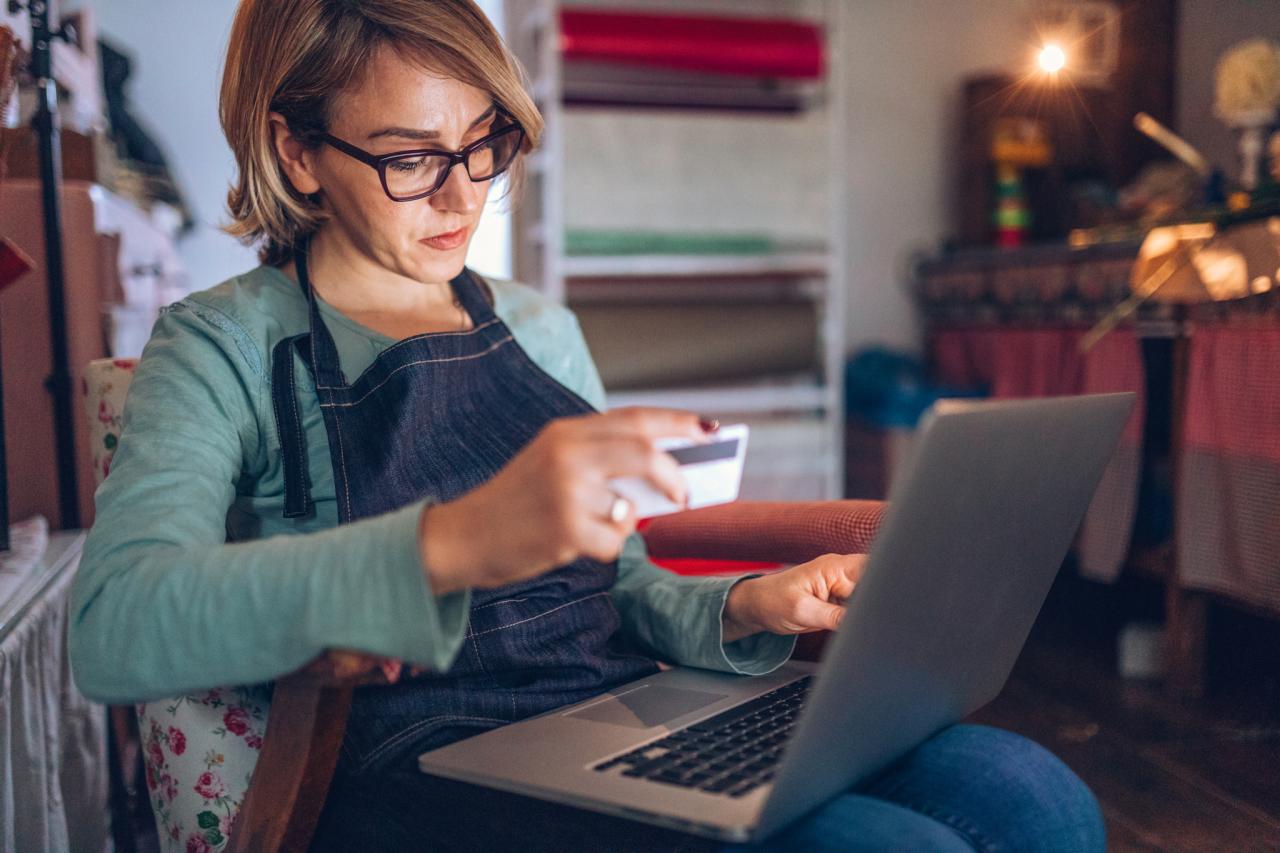 Woman paying for item with laptop and credit card