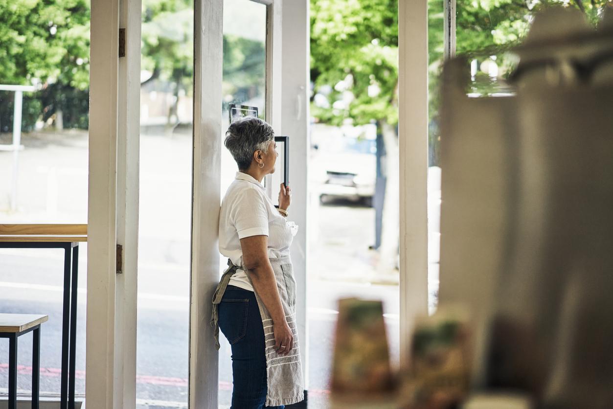 Woman looking out shop doorway