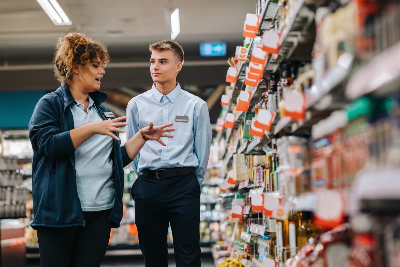 Supermarket manager giving training to a trainee