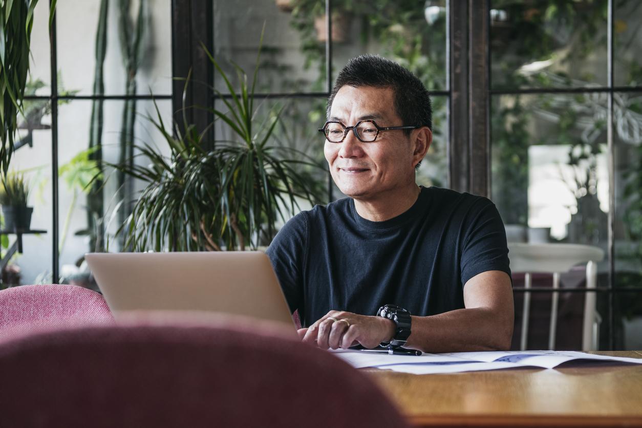 Chinese man working on laptop at home